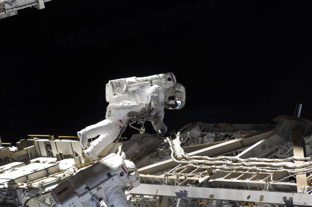 Astronauts participate in extravehicular activity Canvas Art - Stocktrek Images (35 x 23)