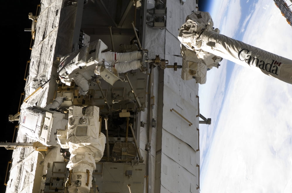 Astronauts participate in extravehicular activity Canvas Art - Stocktrek Images (35 x 23)