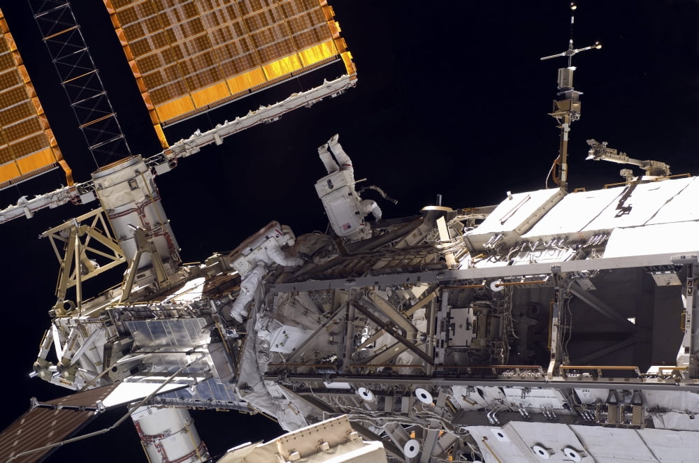 Astronauts participate in extravehicular activity Canvas Art - Stocktrek Images (35 x 23)