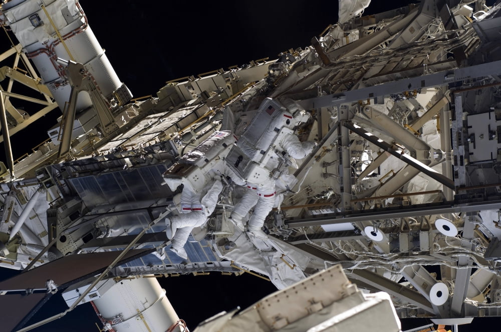 Astronauts participate in extravehicular activity Canvas Art - Stocktrek Images (35 x 23)