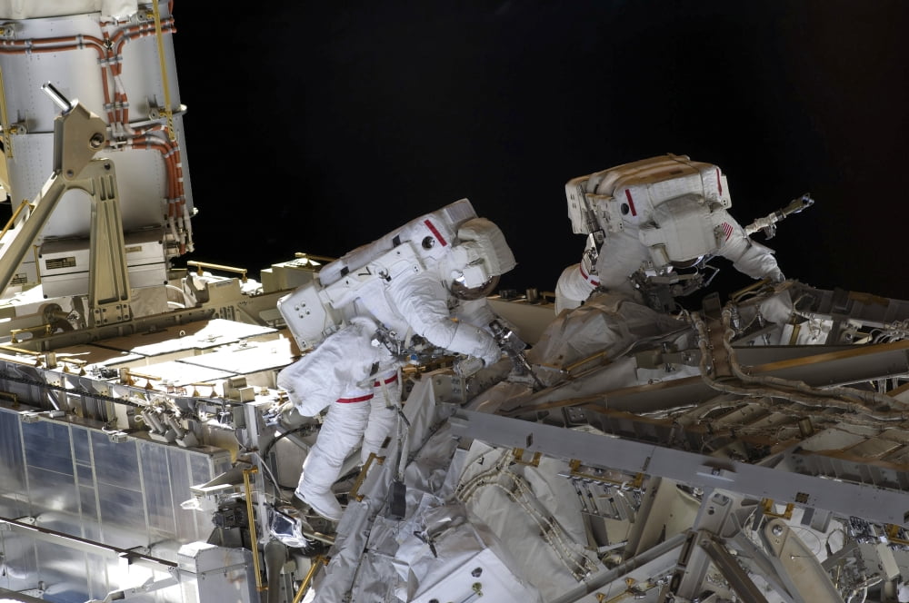 Astronauts participate in extravehicular activity Canvas Art - Stocktrek Images (35 x 23)