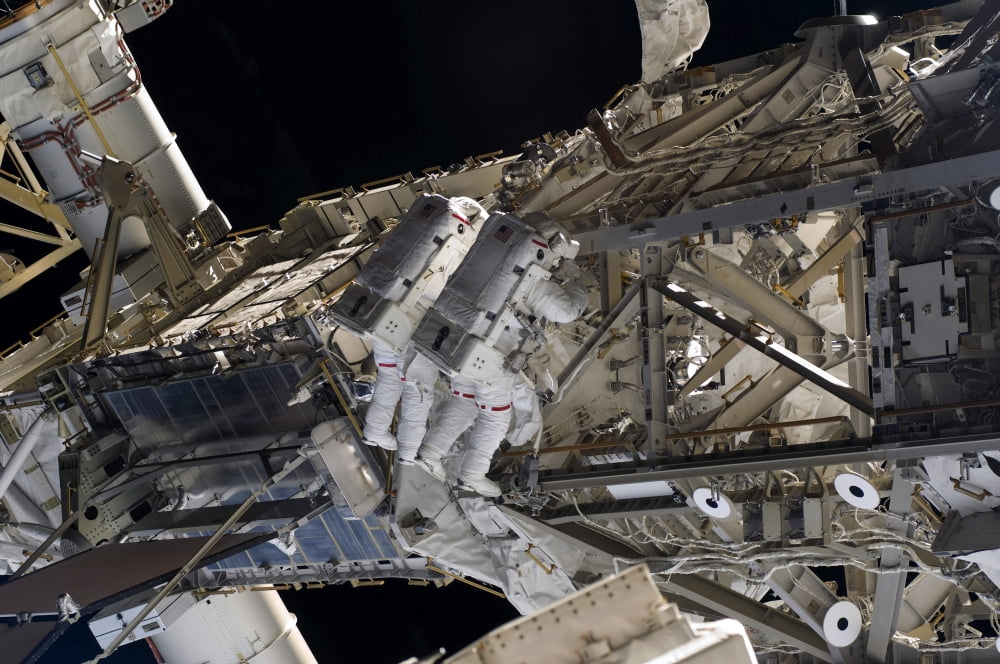Astronauts participate in extravehicular activity Canvas Art - Stocktrek Images (35 x 23)