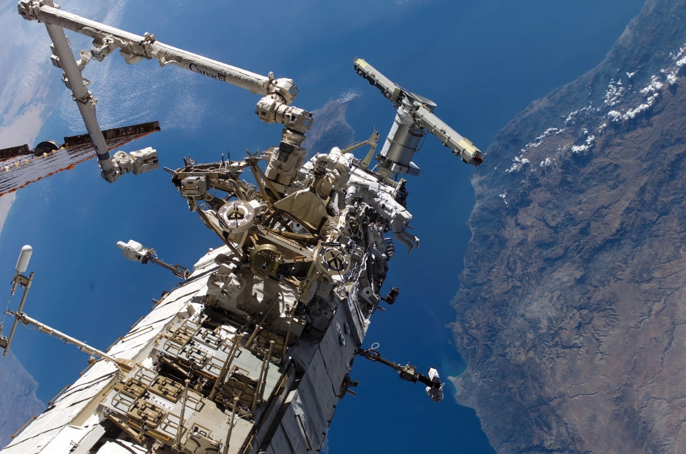Astronauts traversing along the side of one of the International Space Stations trusses Canvas Art - Stocktrek Images (34 x 23)
