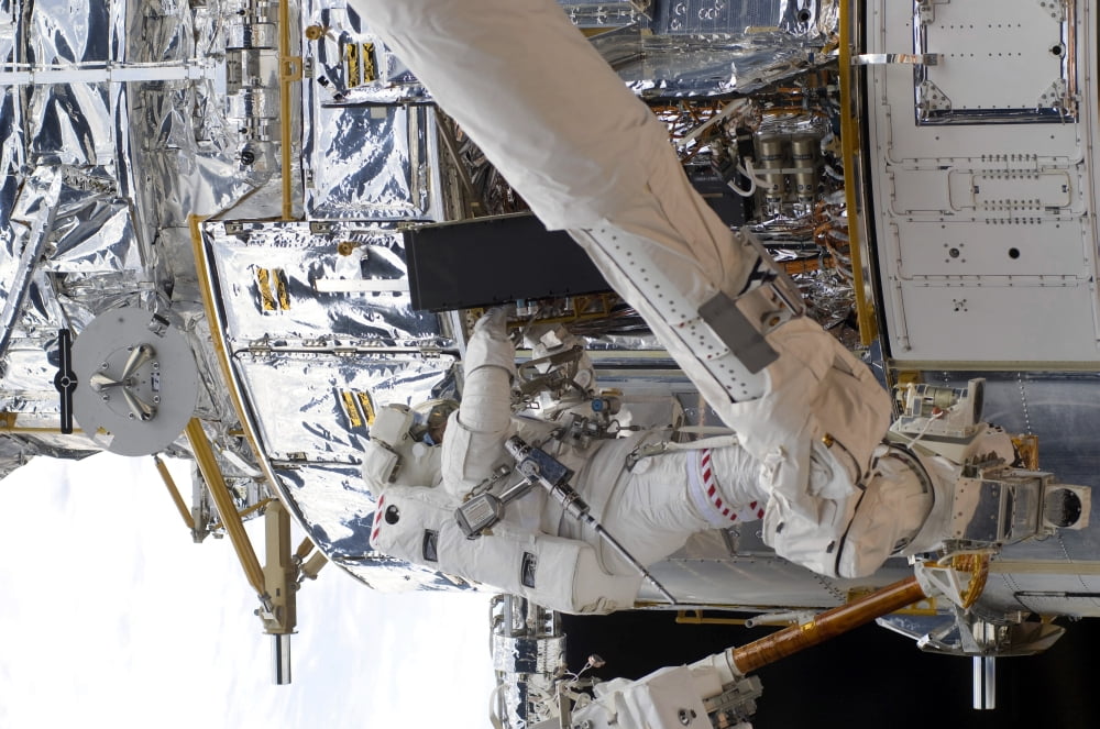 Astronauts working on the Hubble Space Telescope during a spacewalk Canvas Art - Stocktrek Images (34 x 23)