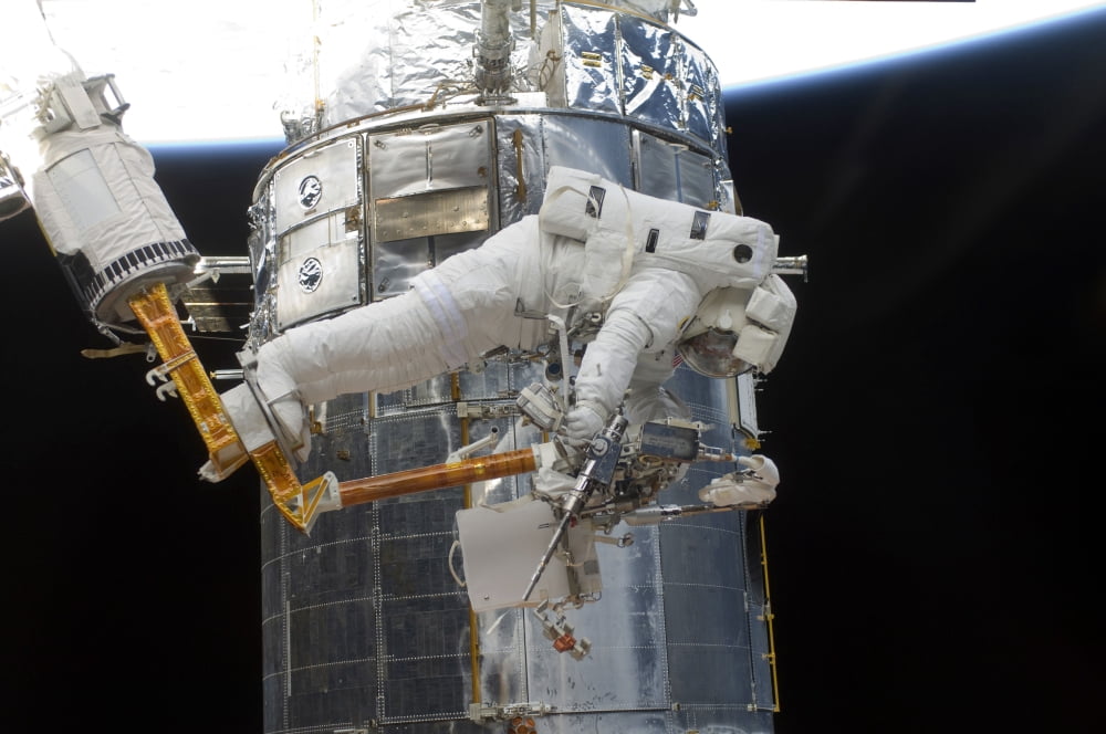 Astronauts working on the Hubble Space Telescope during a spacewalk Canvas Art - Stocktrek Images (34 x 23)