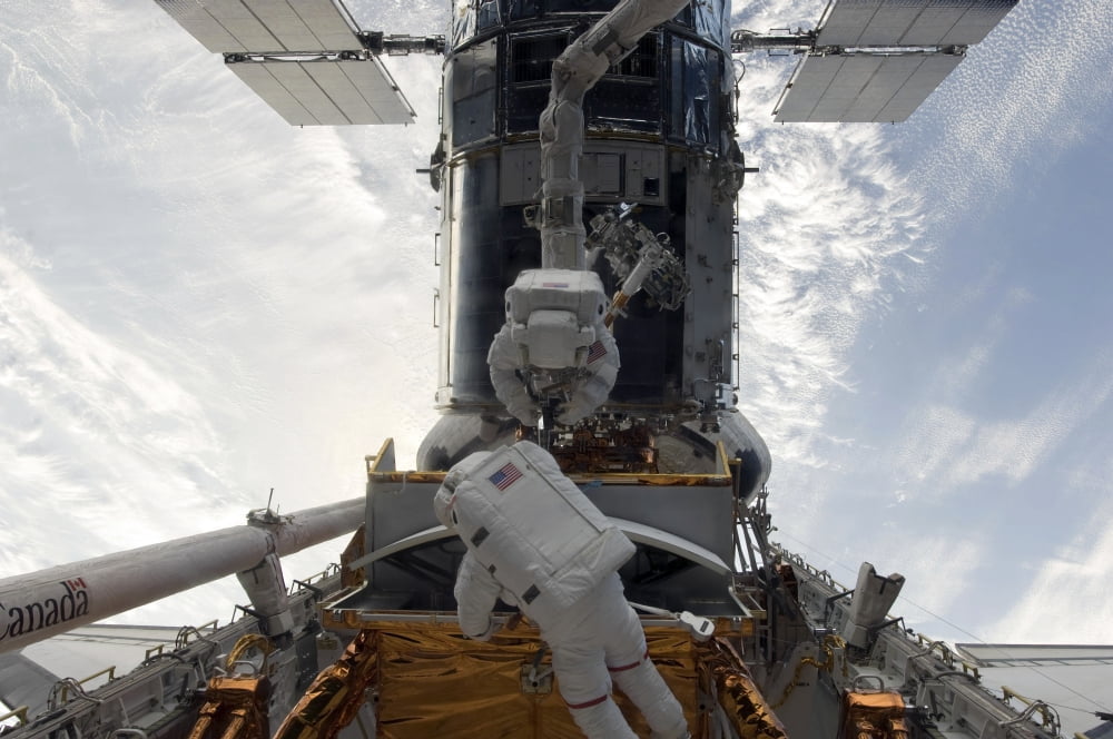 Astronauts working on the Hubble Space Telescope during a spacewalk Canvas Art - Stocktrek Images (34 x 23)