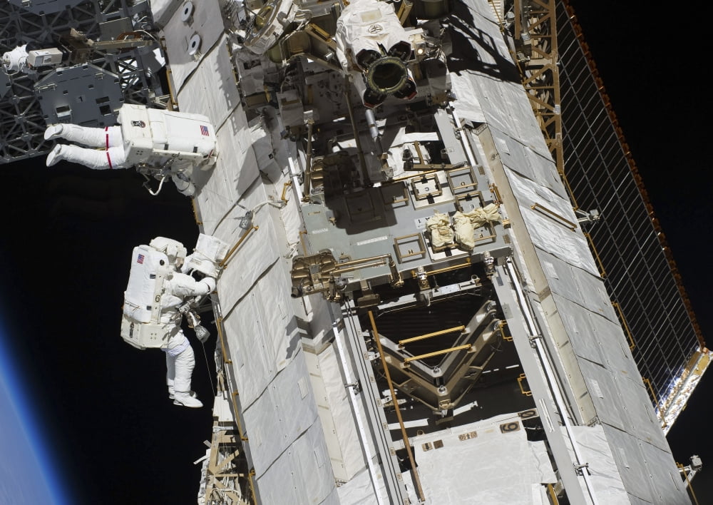 Astronauts working on the International Space Station Canvas Art - Stocktrek Images (33 x 24)