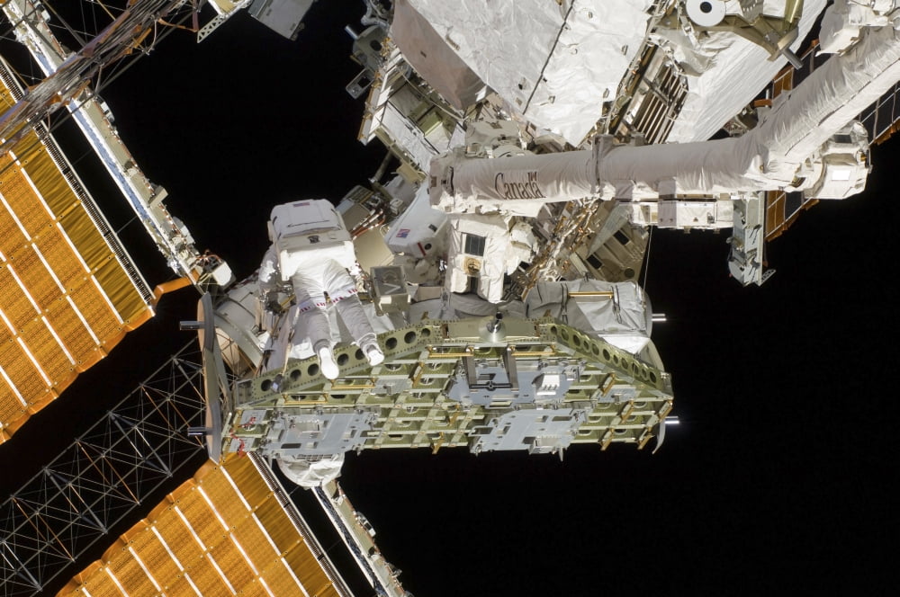 Astronauts working on the International Space Station during a spacewalk Canvas Art - Stocktrek Images (34 x 23)