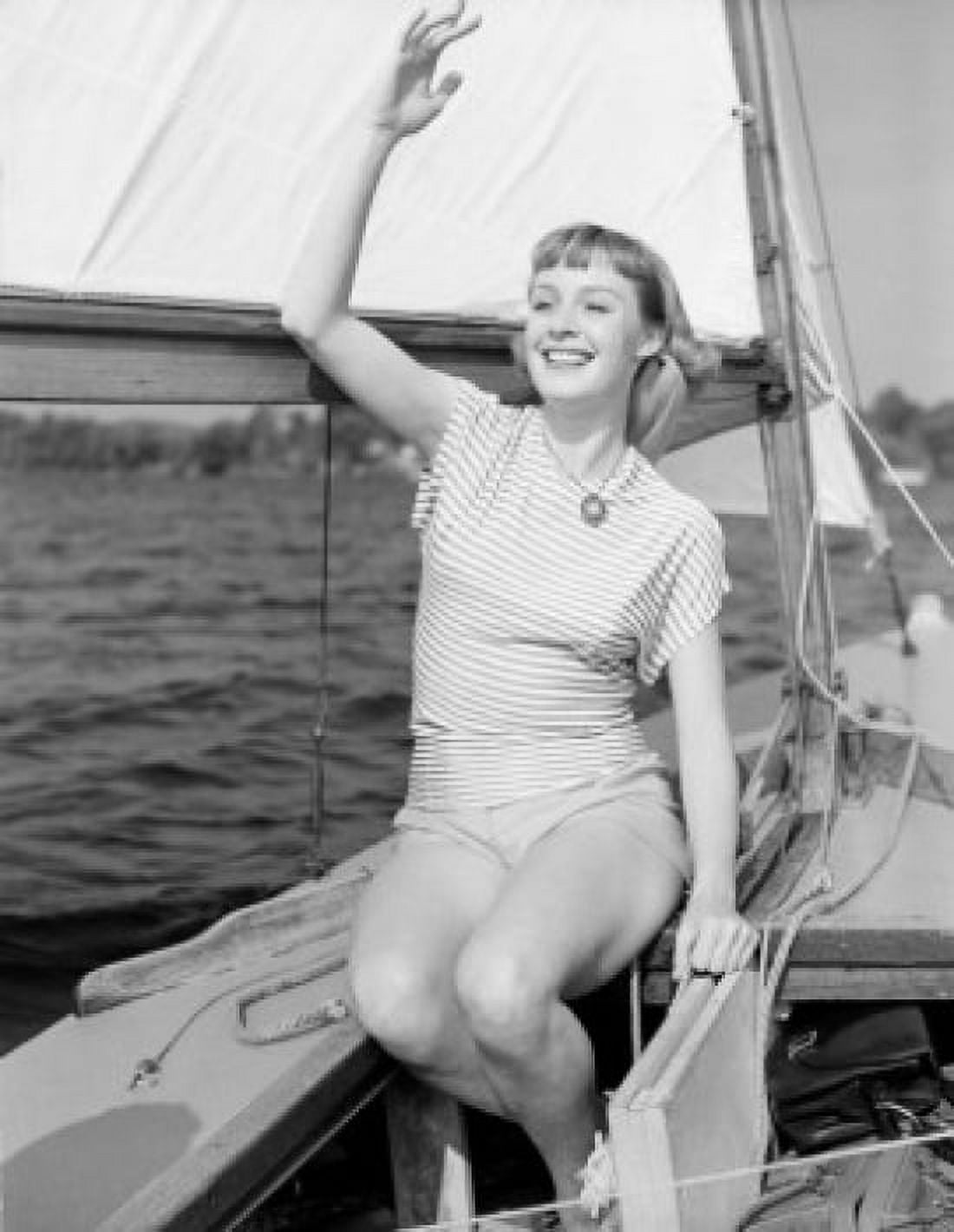 Attractive young woman sitting on yacht deck gesturing Canvas Art - (24 x 36)