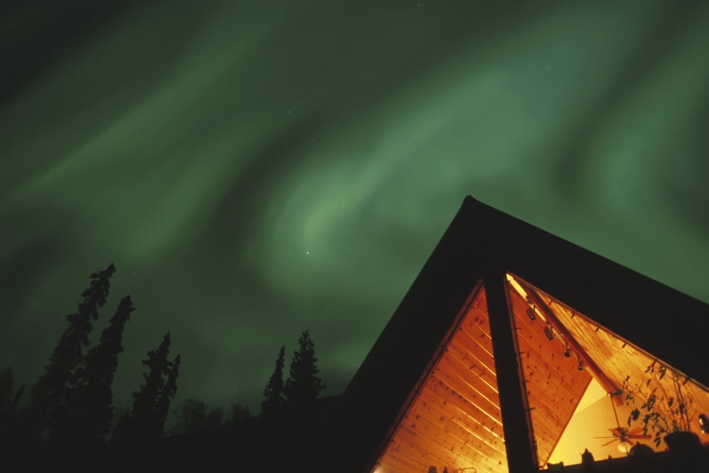 Aurora Borealis Display Above A-Frame House Sc Ak Canvas Art - Michael DeYoung Design Pics (19 x 12)