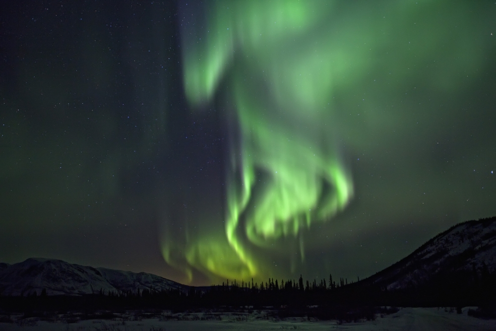 Aurora Borealis Or Northern Lights Above The Mountains Near Whitehorse Yukon Canvas Art - Robert Postma Design Pics (17 x 11)
