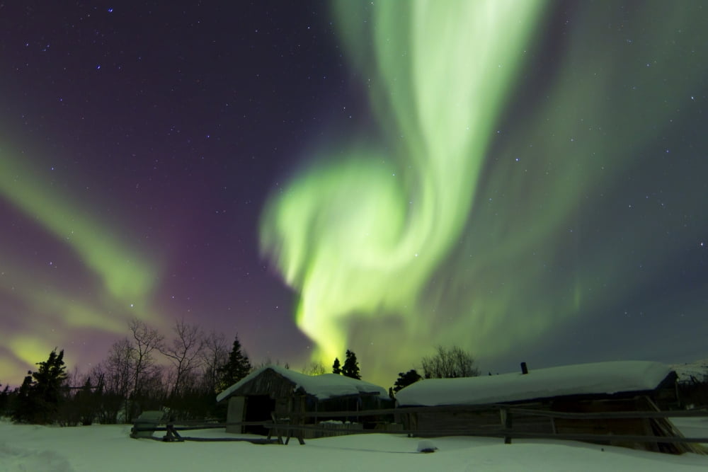 Aurora borealis over a log cabin in Whitehorse Yukon Canada Canvas Art - Joseph BradleyStocktrek Images (18 x 12)