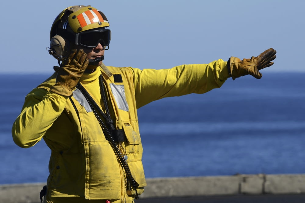 Aviation Boatswains Mate directs an aircraft on the flight deck Canvas Art - Stocktrek Images (35 x 23)