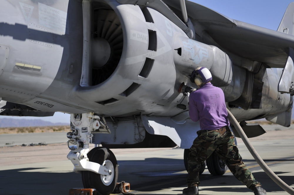 Aviation fuel technician attaches a fuel line to an AV-8B Harrier Canvas Art - Stocktrek Images (35 x 23)