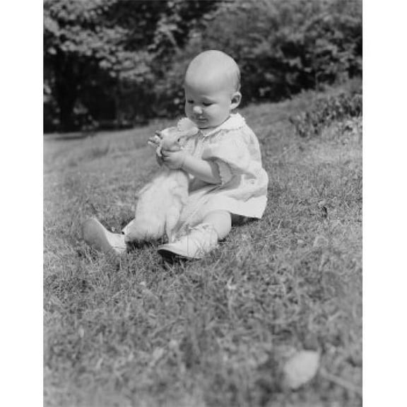 Baby Girl Sitting on Grass Hugging Duck Poster Print - 18 x 24 in.