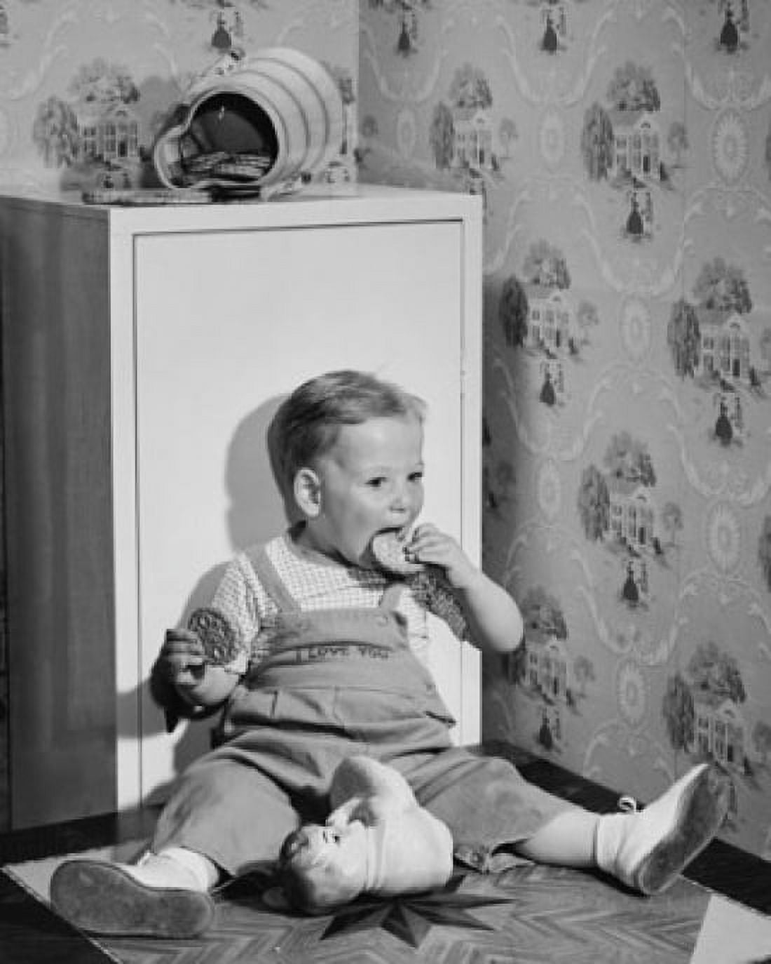 Baby boy leaning against a cabinet and eating cookies Canvas Art - (18 x 24)