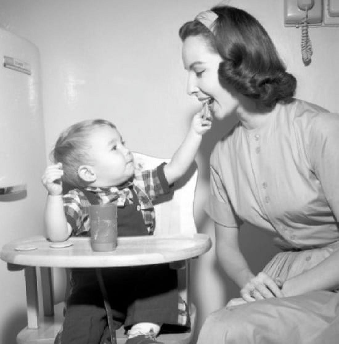 Baby boy sitting in high chair feeding mother with cookie Canvas Art - (18 x 24)