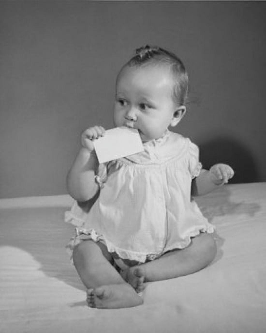Baby girl biting a piece of paper Canvas Art - (18 x 24)