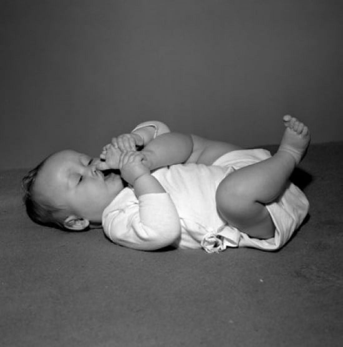 Baby girl lying on back sucking toes Canvas Art -  (18 x 24)