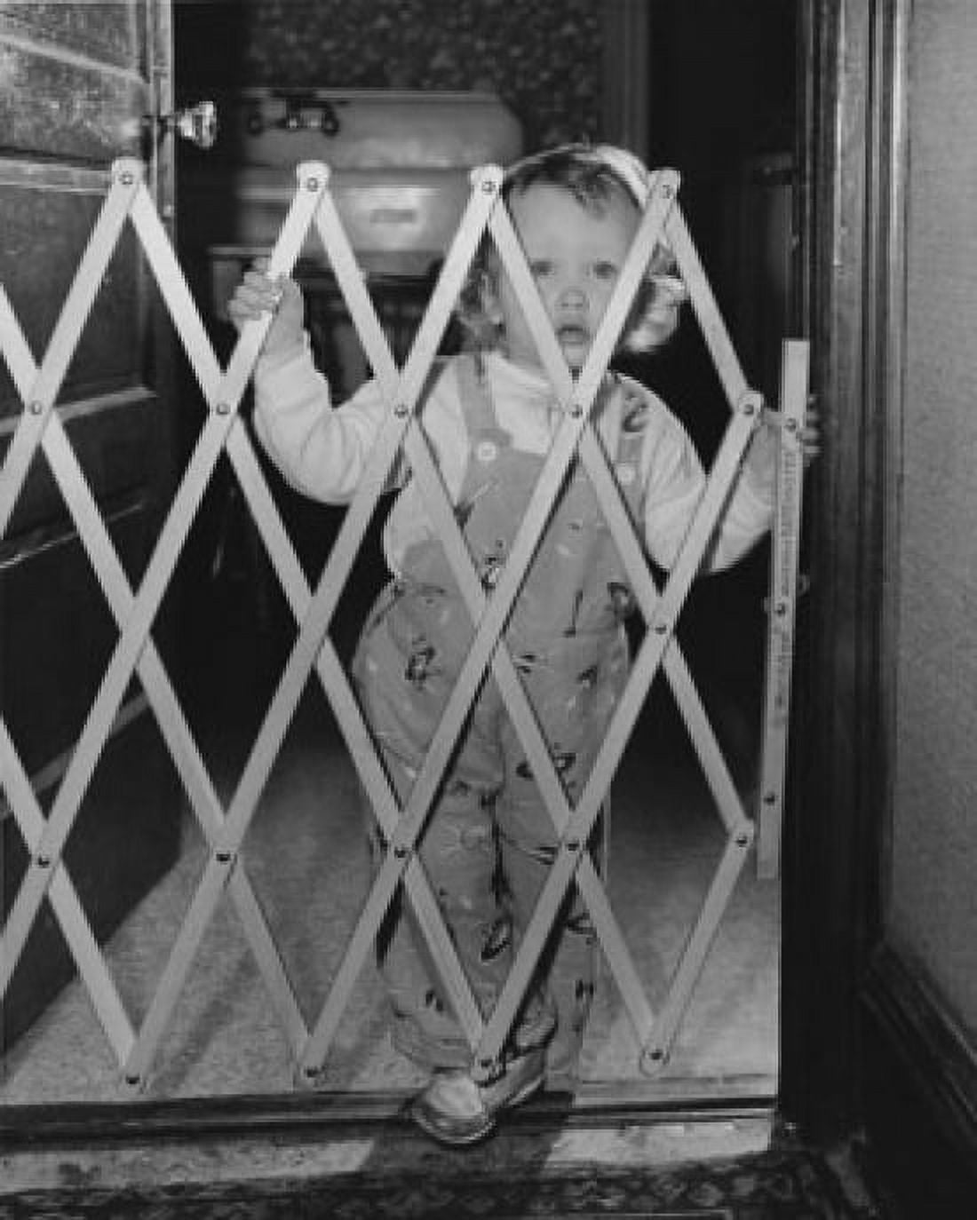 Baby girl standing behind a baby gate Canvas Art - (18 x 24)