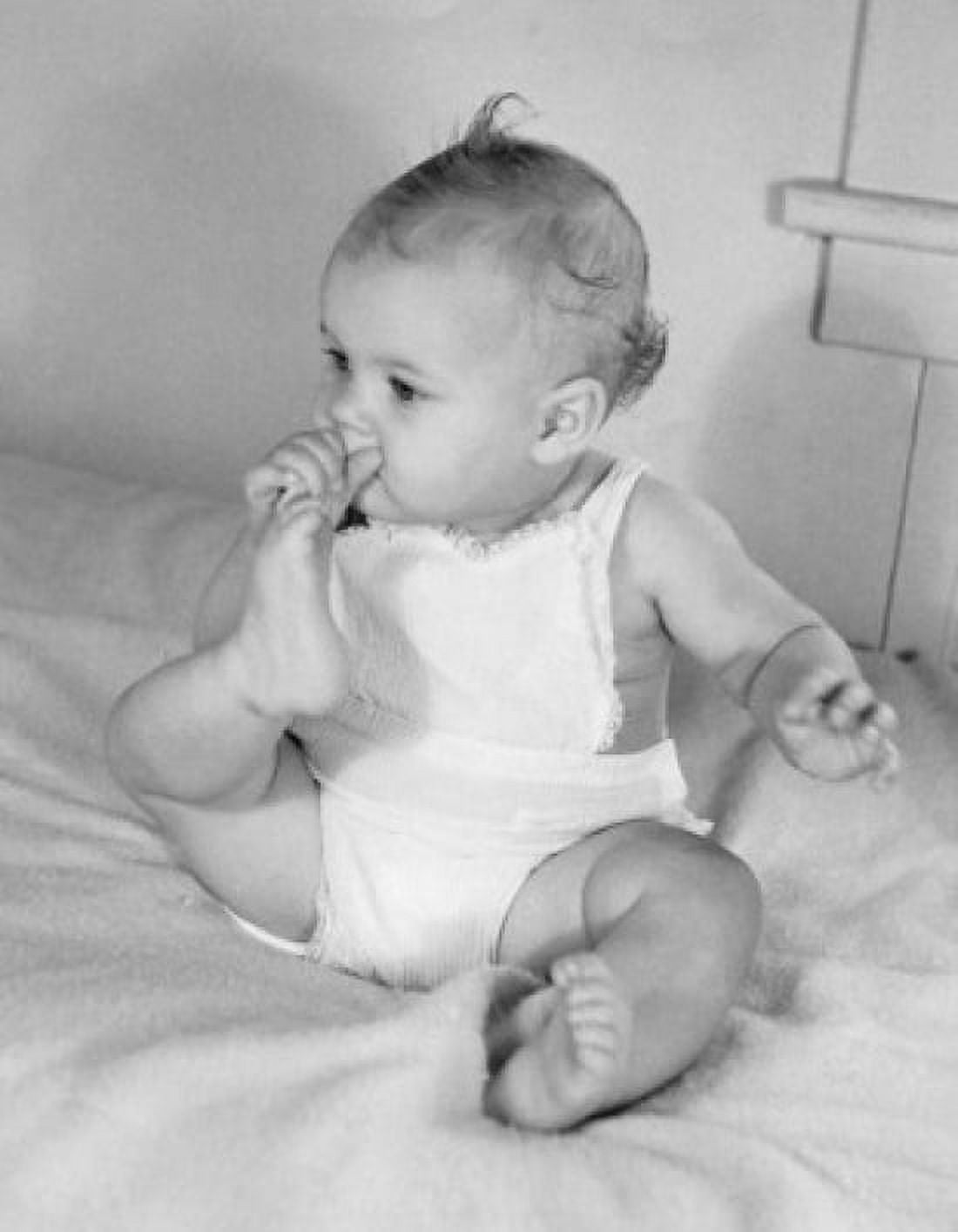 Baby girl sucking toes on bed Canvas Art - (18 x 24)