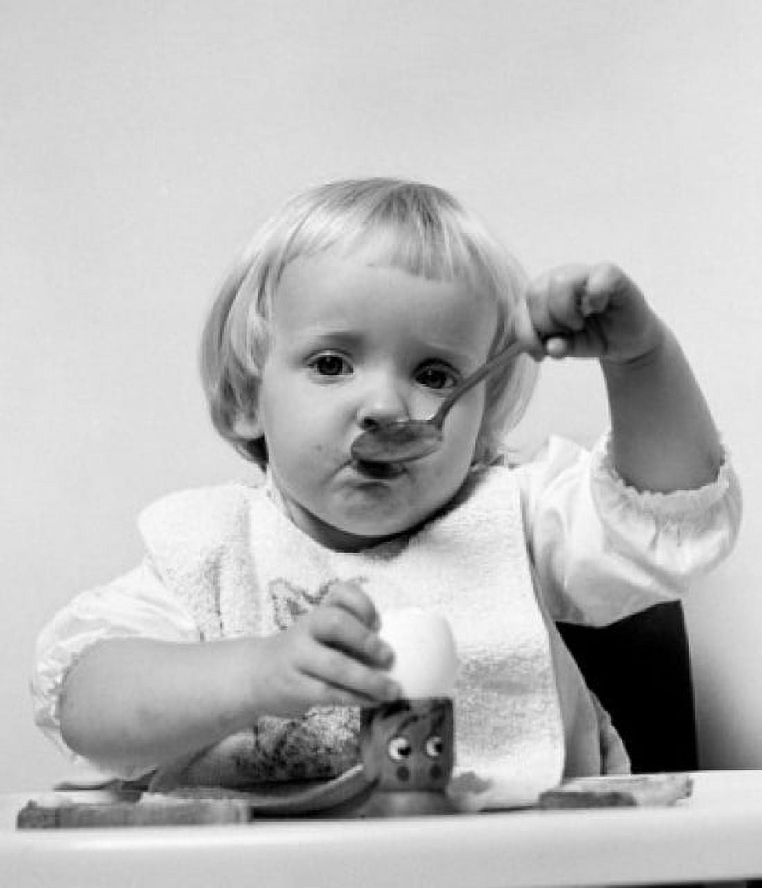 Baby girl with spoon eating egg Canvas Art - (24 x 36)