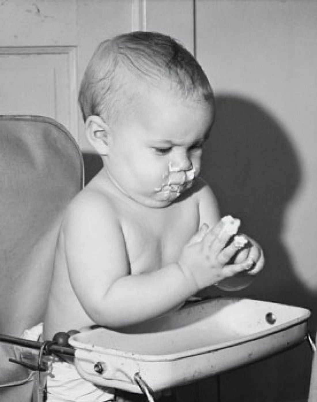 Baby sitting in a high chair and eating food Canvas Art - (18 x 24)