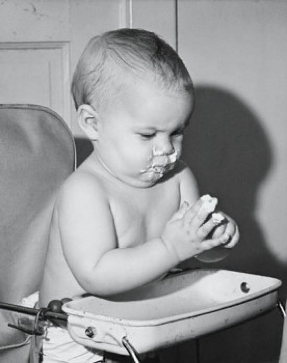 Baby sitting in a high chair and eating food Canvas Art - (24 x 36)