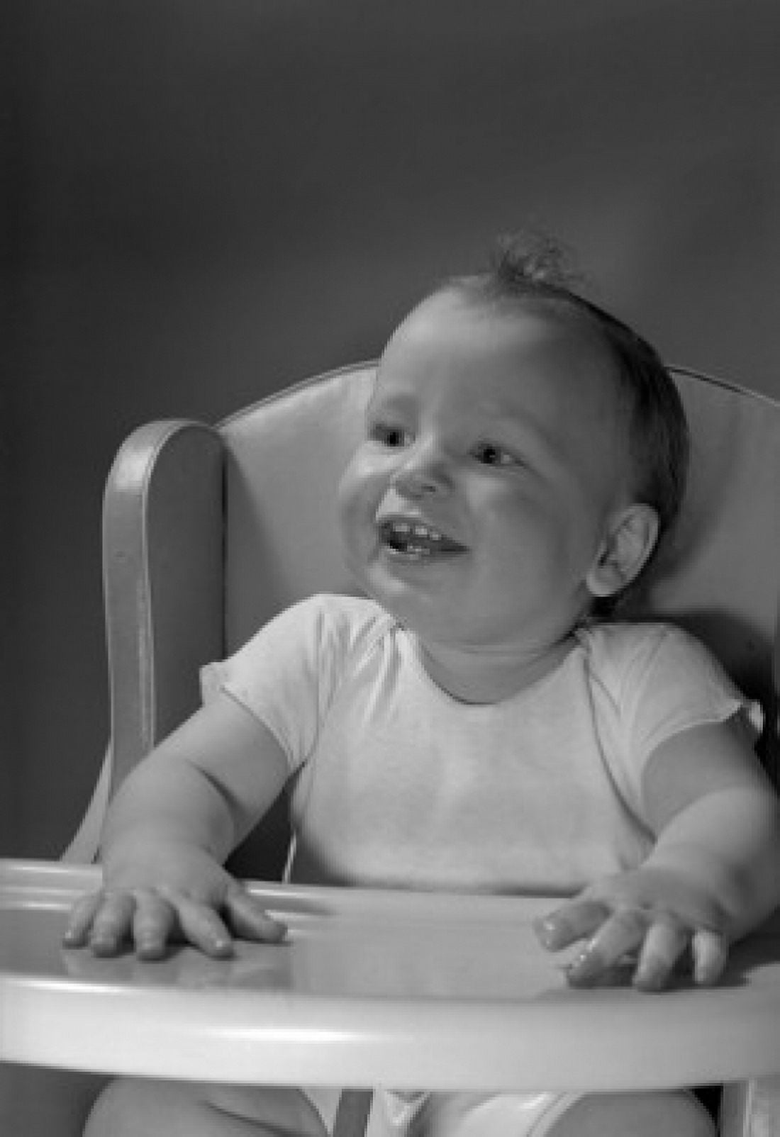 Baby sitting in high chair smiling Canvas Art - (18 x 24)