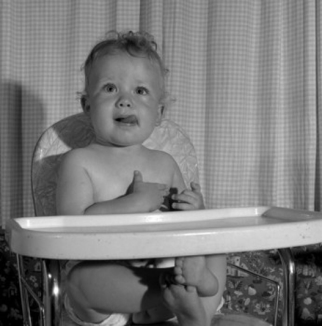 Baby sitting in high chair sticking out tongue Canvas Art - (18 x 24)