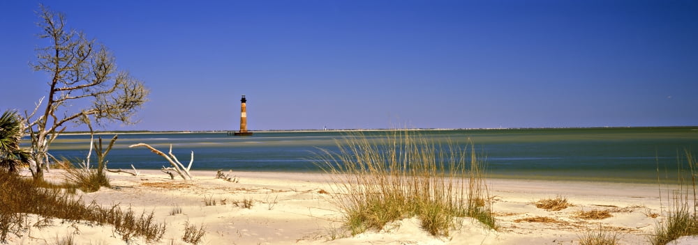 Beach with lighthouse in the background Morris Island Lighthouse Morris Island South Carolina USA Canvas Art - Panoramic Images (27 x 9)
