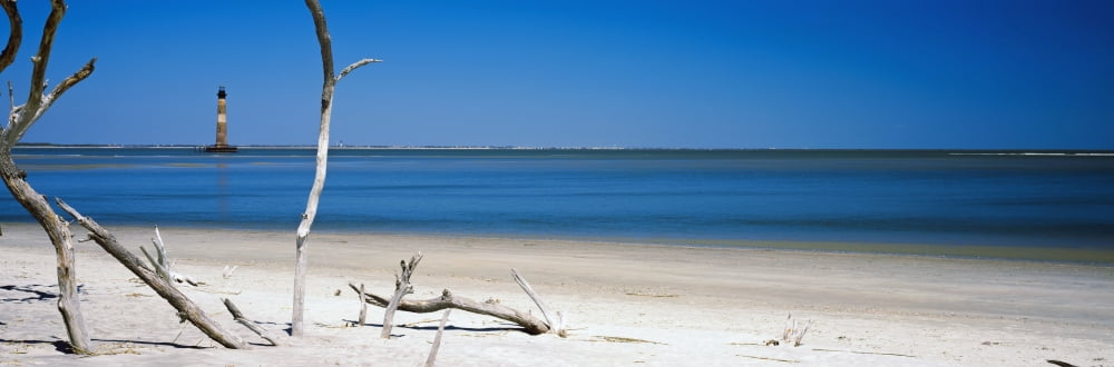 Beach with lighthouse in the background Morris Island Lighthouse Morris Island South Carolina USA Canvas Art - Panoramic Images (27 x 9)