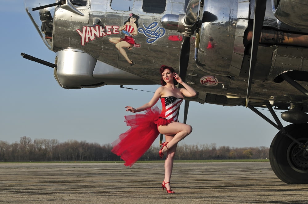 Beautiful 1940s style pin-up girl standing in front of a B-17 bomber Canvas Art - Christian KiefferStocktrek Images (18 x 12)