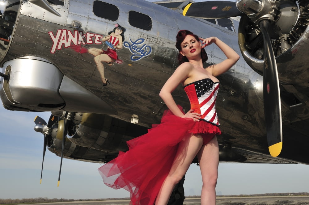 Beautiful 1940s style pin-up girl standing under a B-17 bomber Canvas Art - Christian KiefferStocktrek Images (35 x 23)