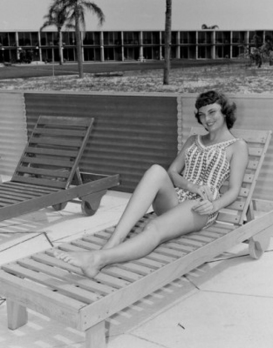 Beauty young woman sitting on lounge chair looking at camera and smiling Canvas Art - (24 x 36)