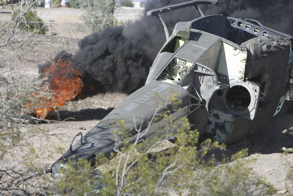 Black smoke rises to the air from a simulated wreckage of a downed UH-1N Huey Canvas Art - Stocktrek Images (35 x 23)