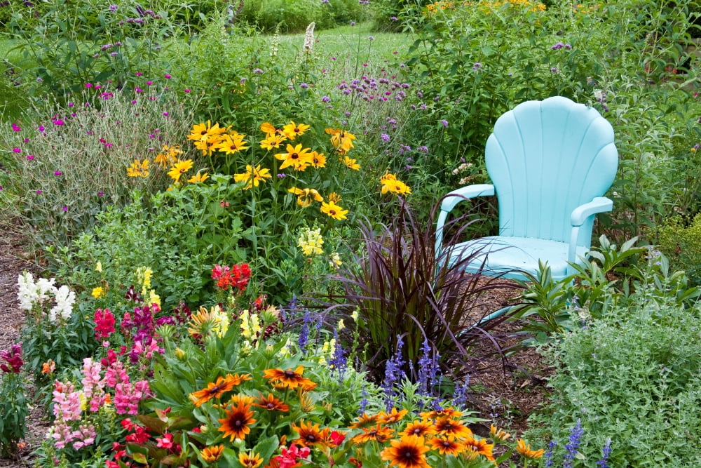 Blue chair and various flowers in a garden Marion County Illinois USA Canvas Art - Panoramic Images (24 x 36)