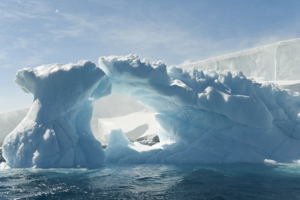 Blue iceberg with sun overhead ice cap of Anderson Island in the Antarctic Sound Antarctic peninsula Canvas Art - Daisy Gilardini  Design Pics (19 x 12)