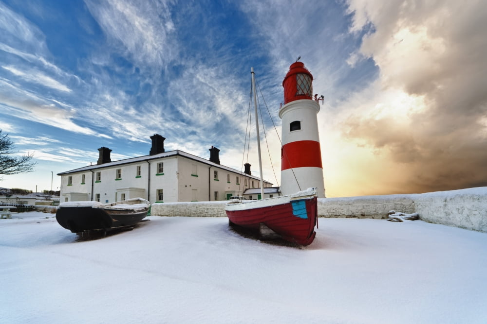 Boats Sitting On A Frozen Surface With A Lighthouse And Building In The Background South Shields Tyne And Wear England Canvas Art - John Short Design Pics (19 x 12)