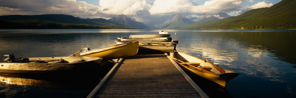 Boats moored at a dock McDonald Lake US Glacier National Park Montana USA Canvas Art - Panoramic Images (36 x 12)
