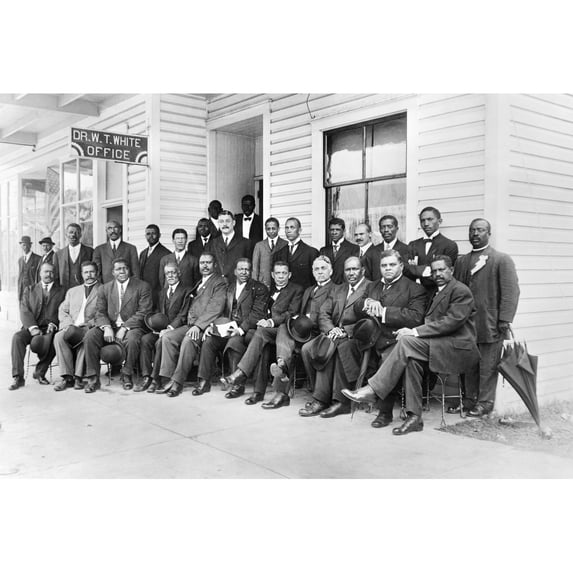 Booker T. Washington N(1856-1915). American Educator. Mr. Washington Seated With Group Of Men Outside The Office Of Dr.