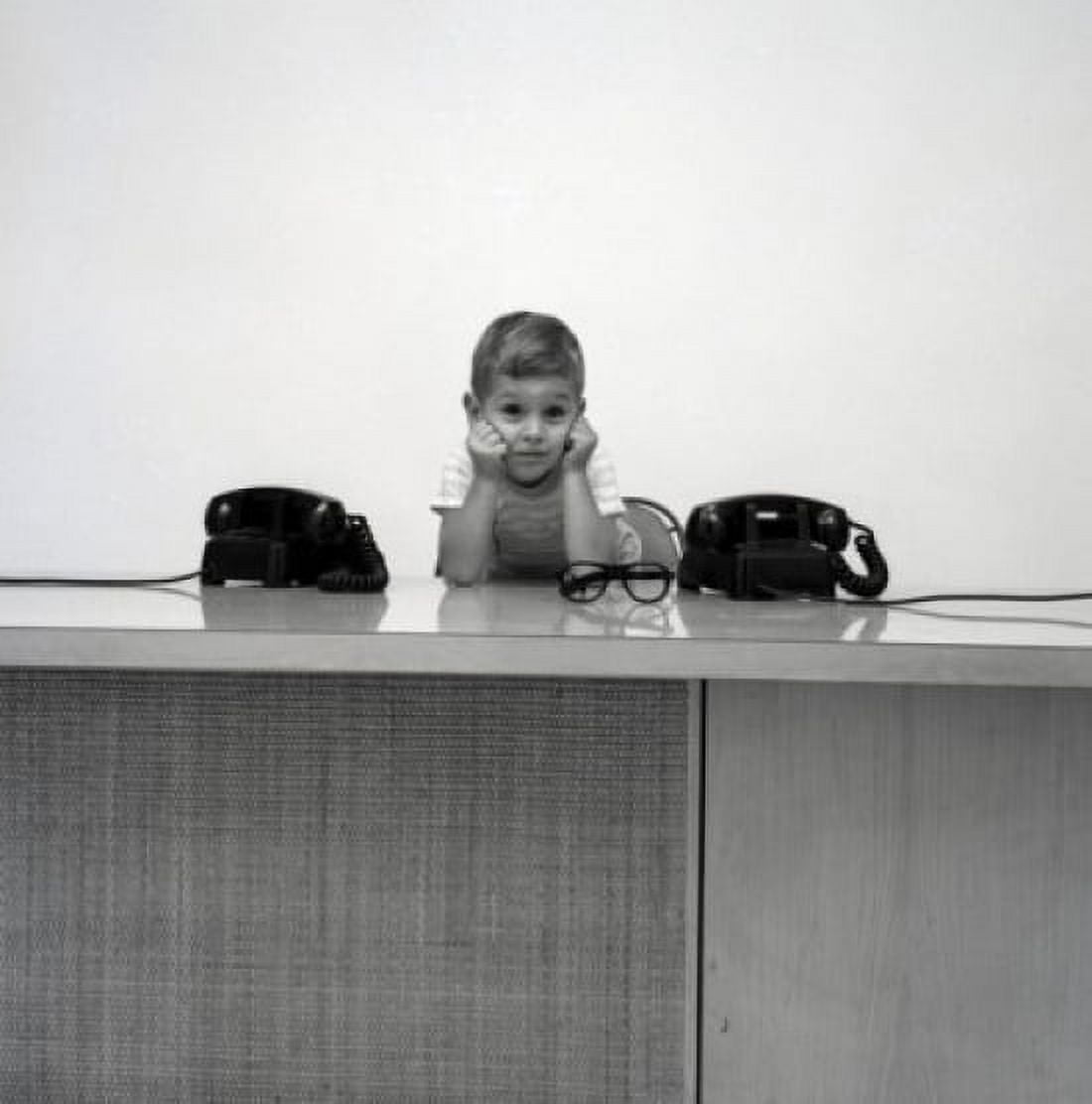 Bored boy sitting at desk with telephones Canvas Art - (18 x 24)