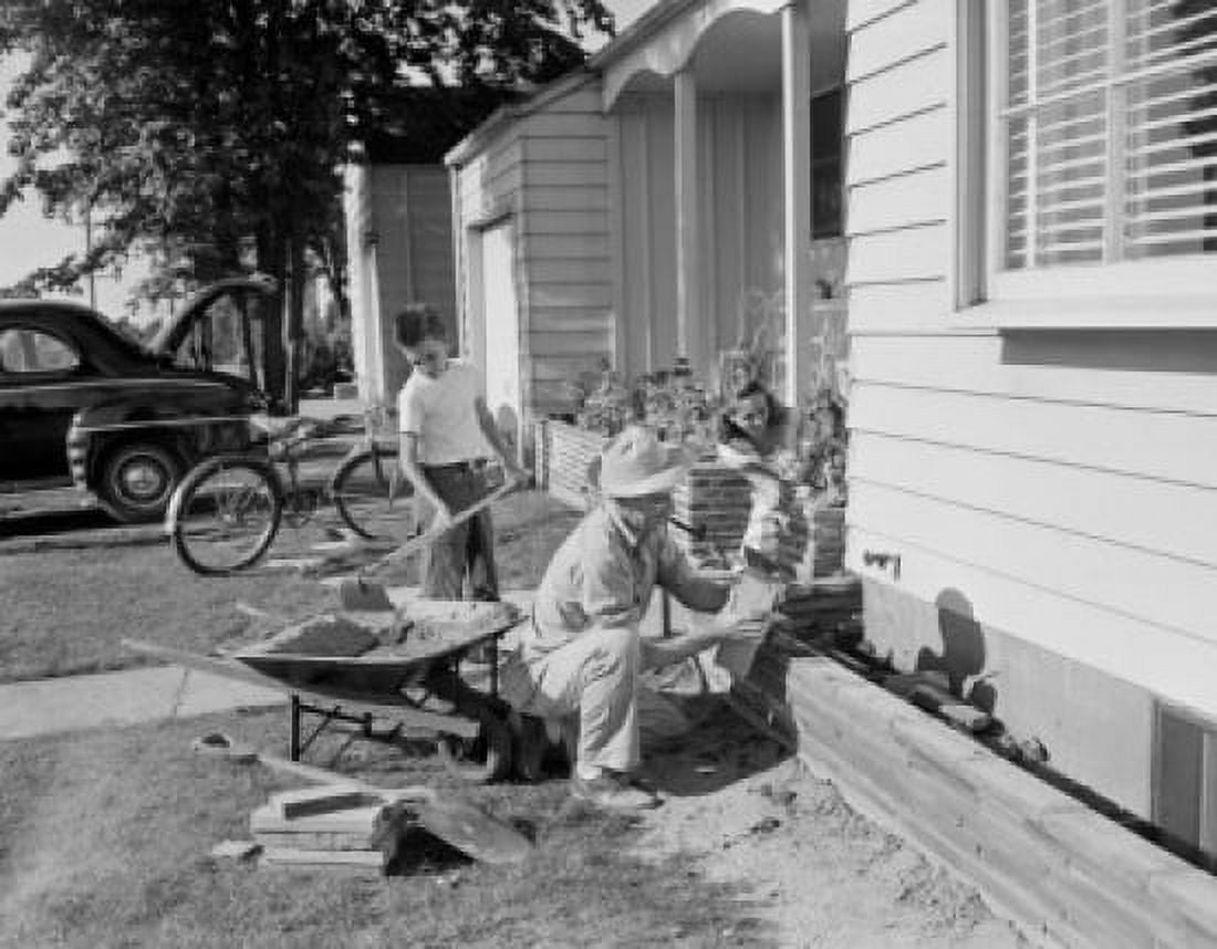 Boy and farther doing small masonry work outside suburban home Canvas Art - (24 x 36)