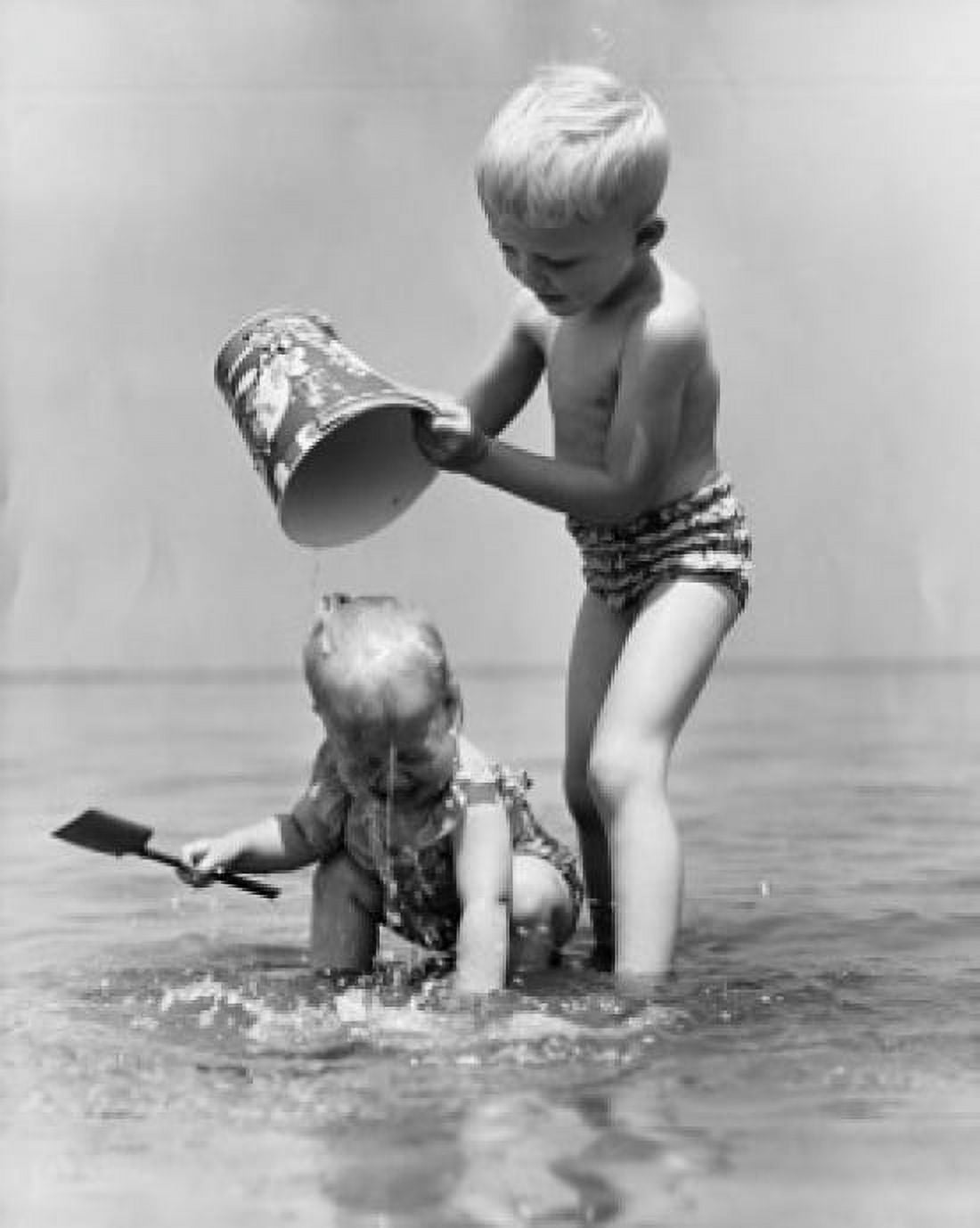 Boy and girl playing in water Canvas Art - (24 x 36)