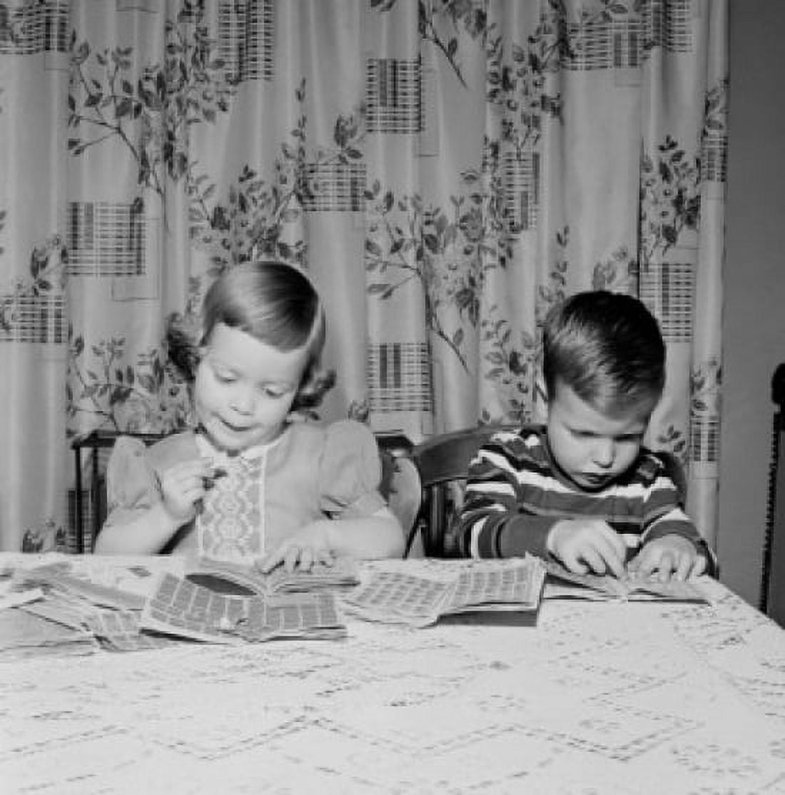 Boy and girl putting post stamps into stamp album Canvas Art - (24 x 36)
