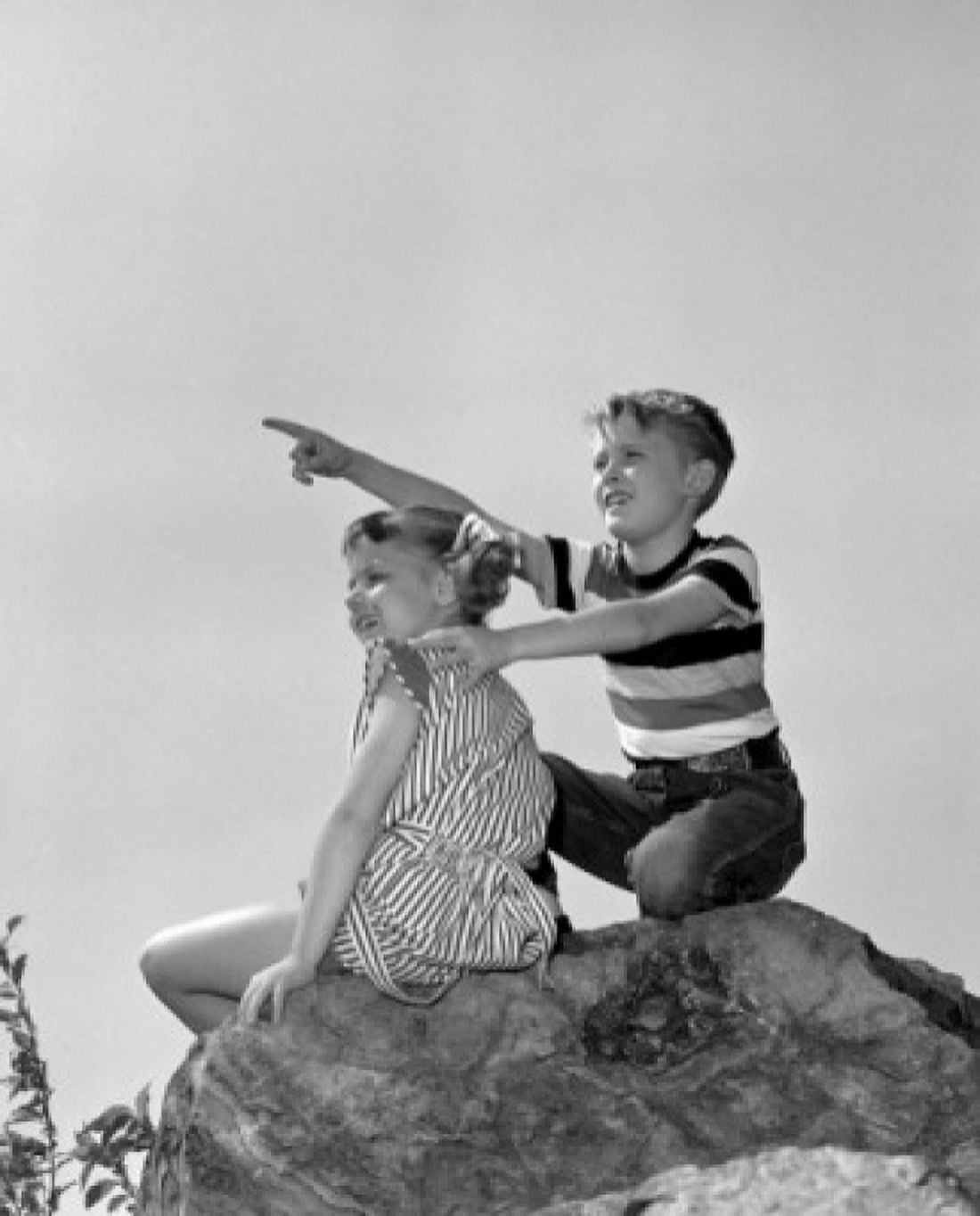 Boy and girl sitting on top of rock an looking at view Canvas Art - (24 x 36)
