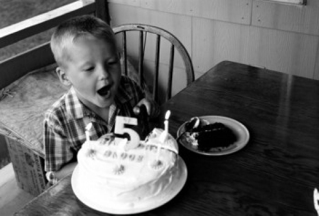 Boy blowing at candle on birthday cake Canvas Art - (18 x 24)
