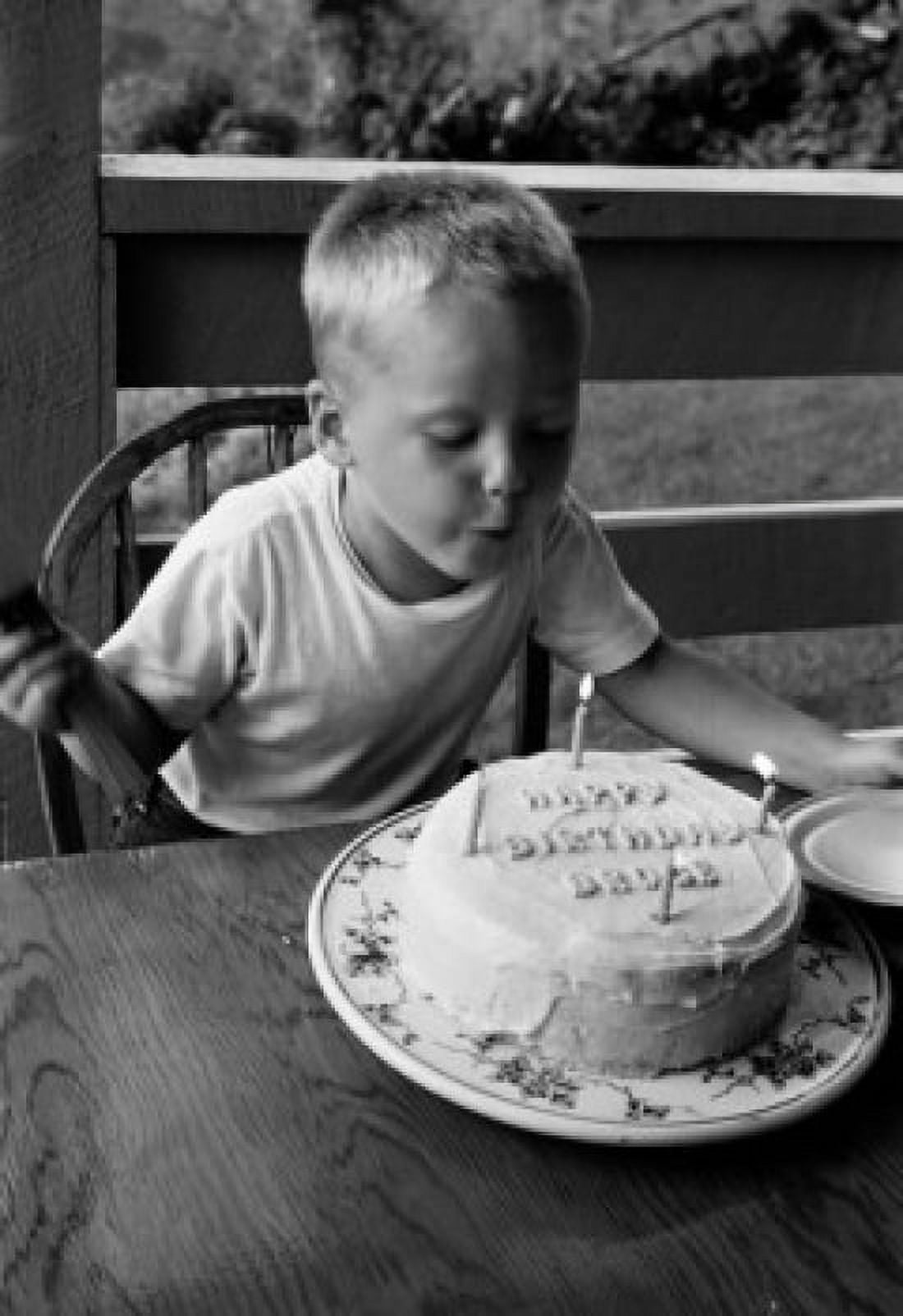 Boy blowing candle on birthday cake Canvas Art - (24 x 36)