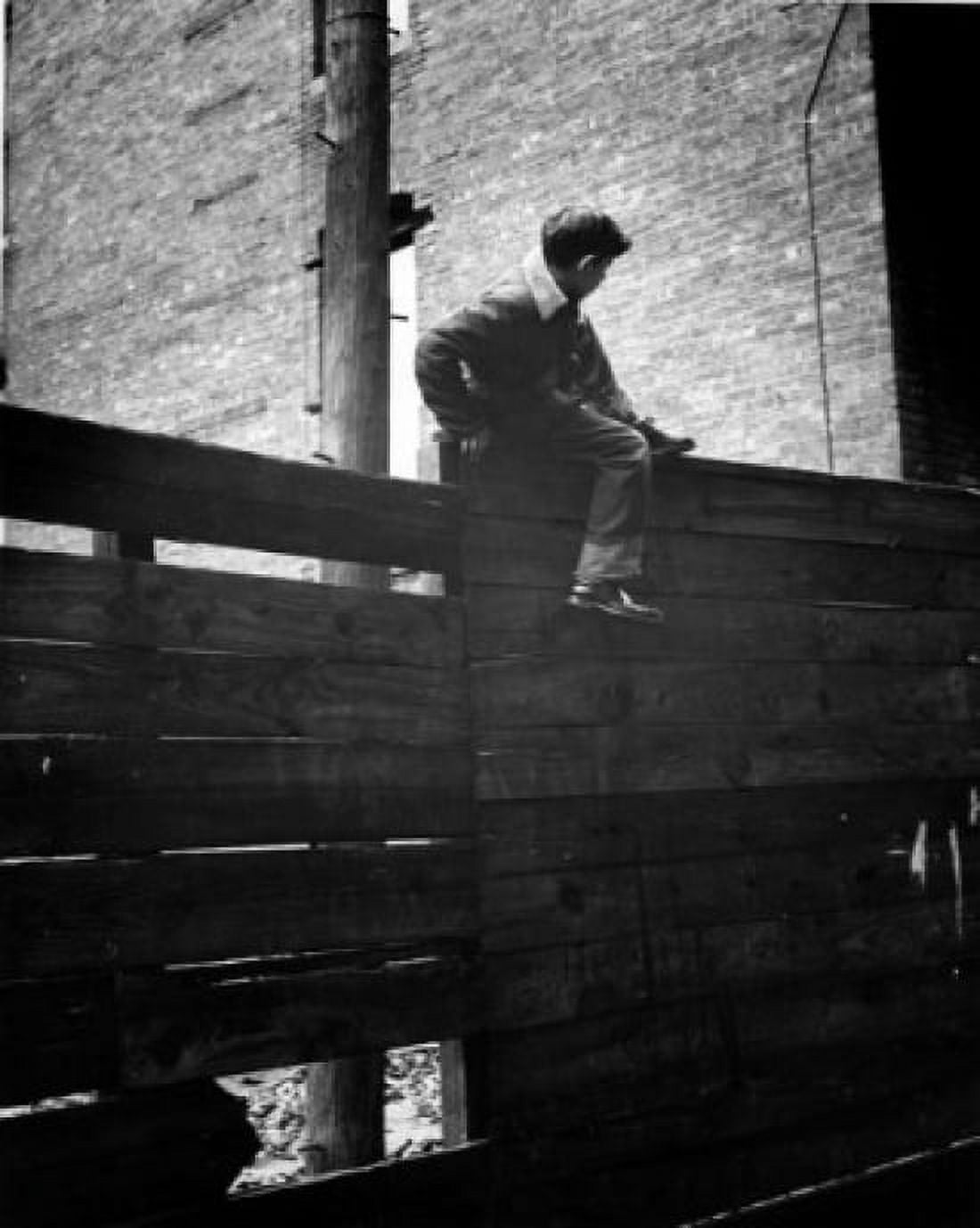 Boy climbing over fence Canvas Art - (18 x 24)