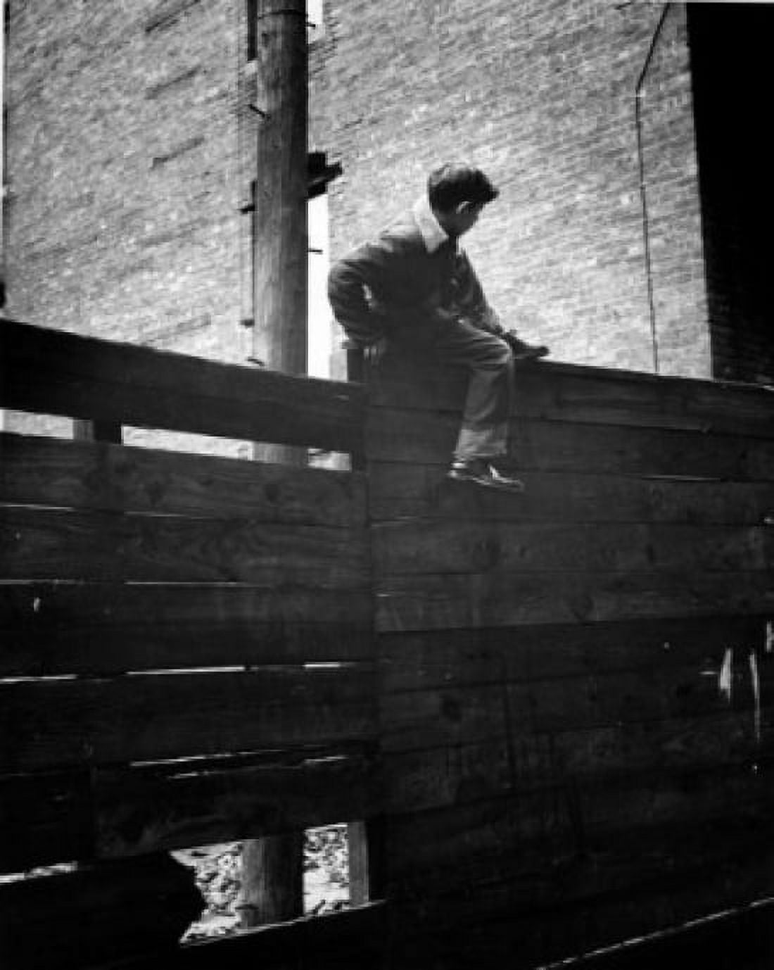 Boy climbing over fence Canvas Art - (24 x 36)